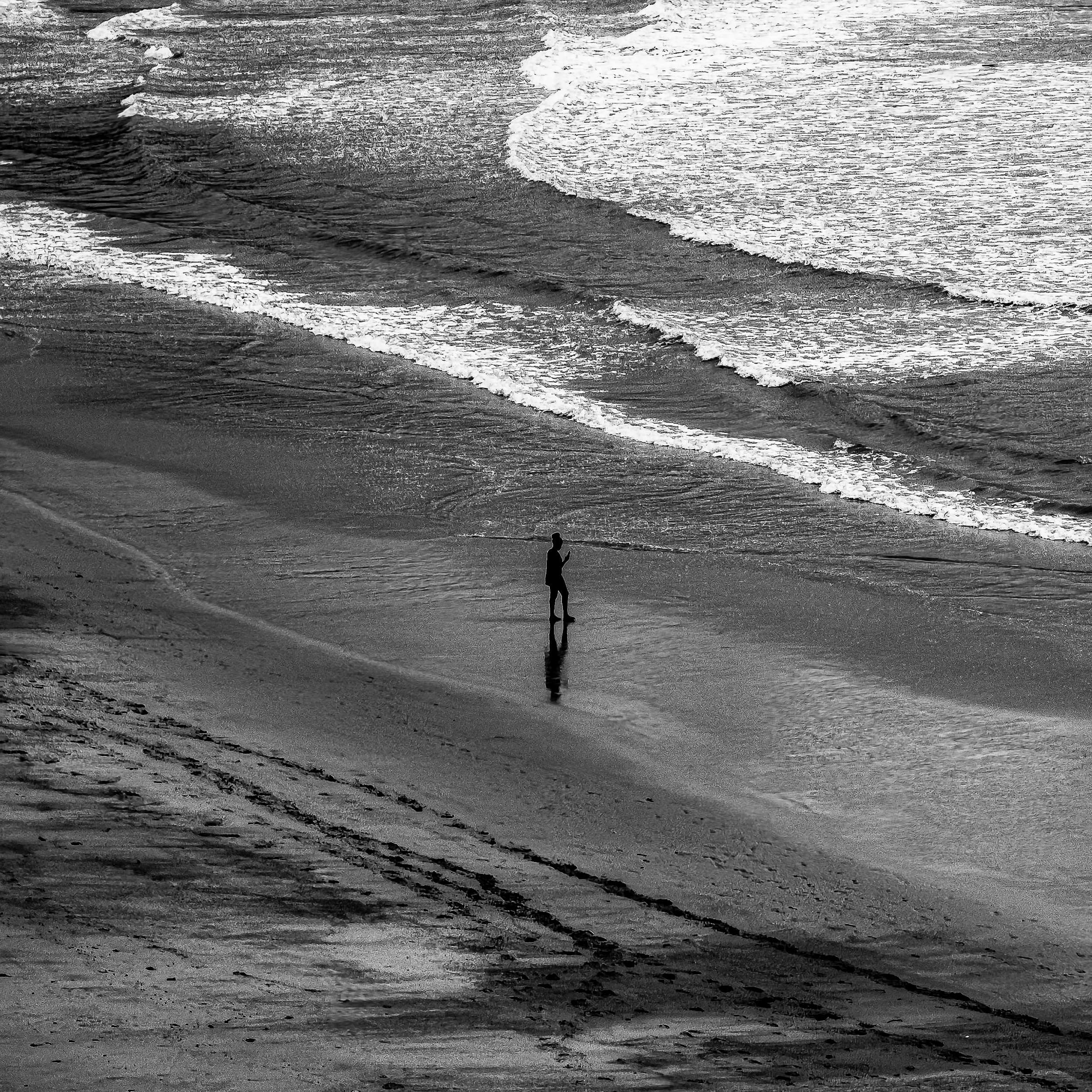 A solitary silhouette reflected at the shoreline